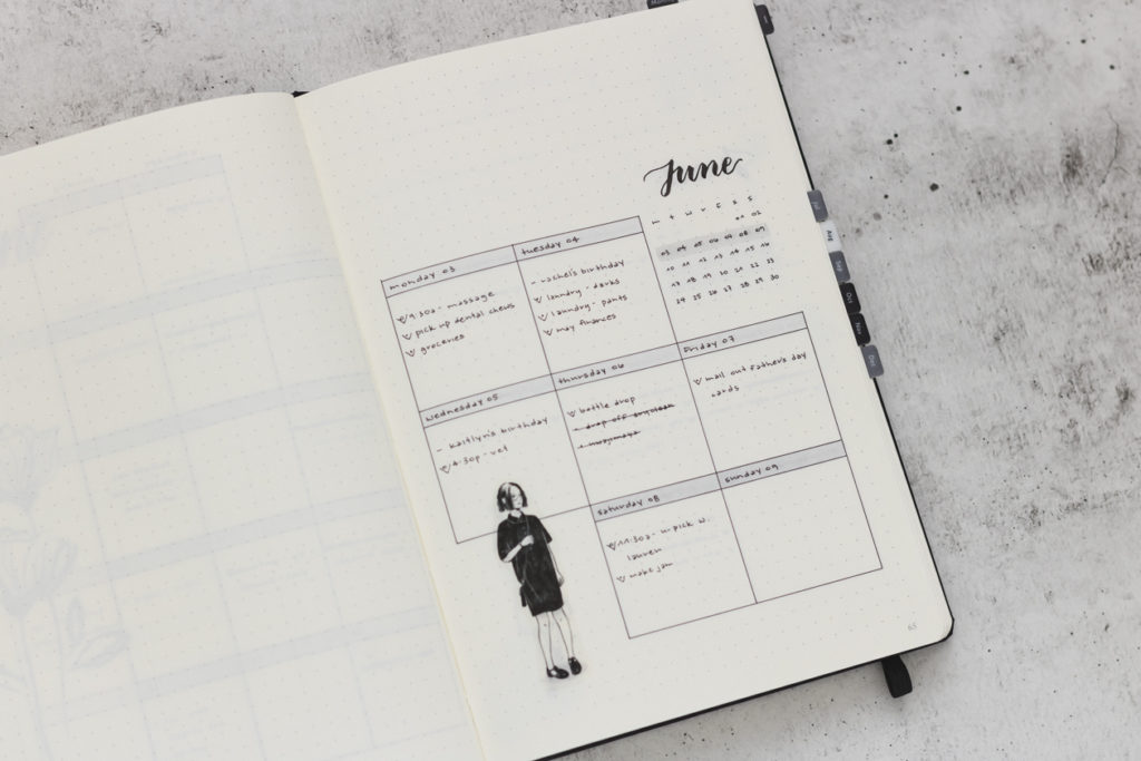 one page weekly bullet journal layout in a grey-scale colorway with a sticker of a girl